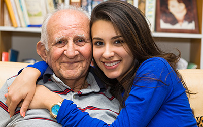 Young Hispanic woman hugging older man