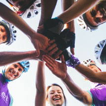 Image of several people putting their hands together in a group