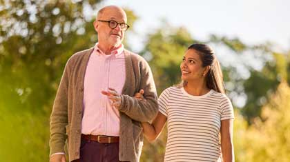Caregiver walks with a person living with Alzheimer's