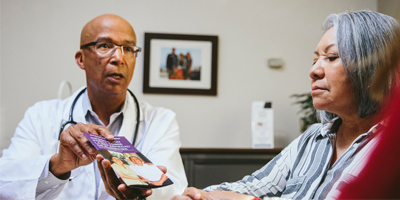 A doctor talks to a patient in an exam room