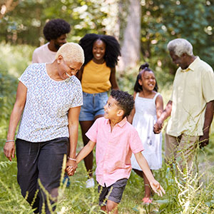Smiling intergenerational family walking together through grass